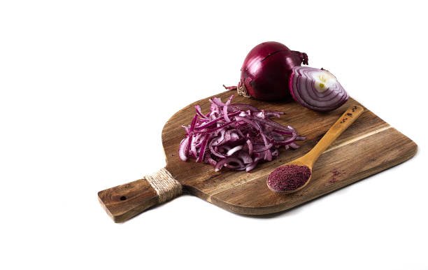 Sliced into half rings, red onion, with Sumac spice, on a white background, no people,