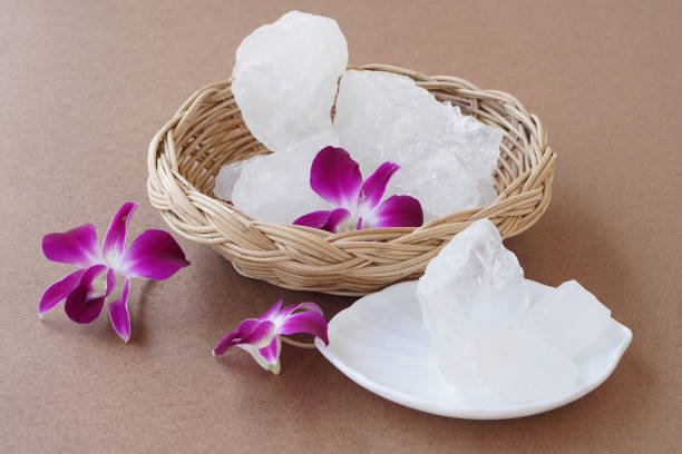 Crystal clear alum stones or Potassium alum decorated with orchid flowers. Useful for beauty and spa treatment. Use to treat body odor under the armpits as deodorant and make water clear.